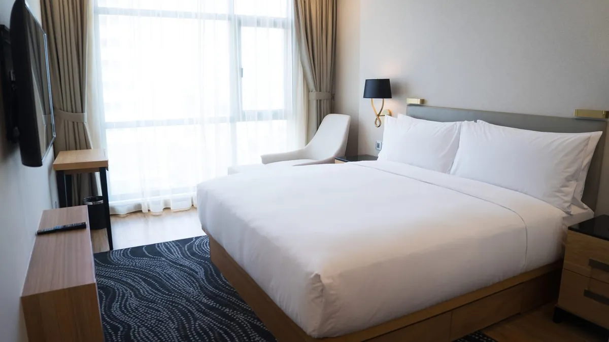 A double room with a large bed and floor-to-ceiling windows.