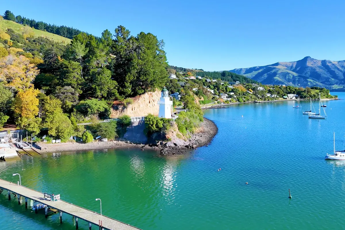 El faro y los veleros fondeados en el puerto de Akaroa