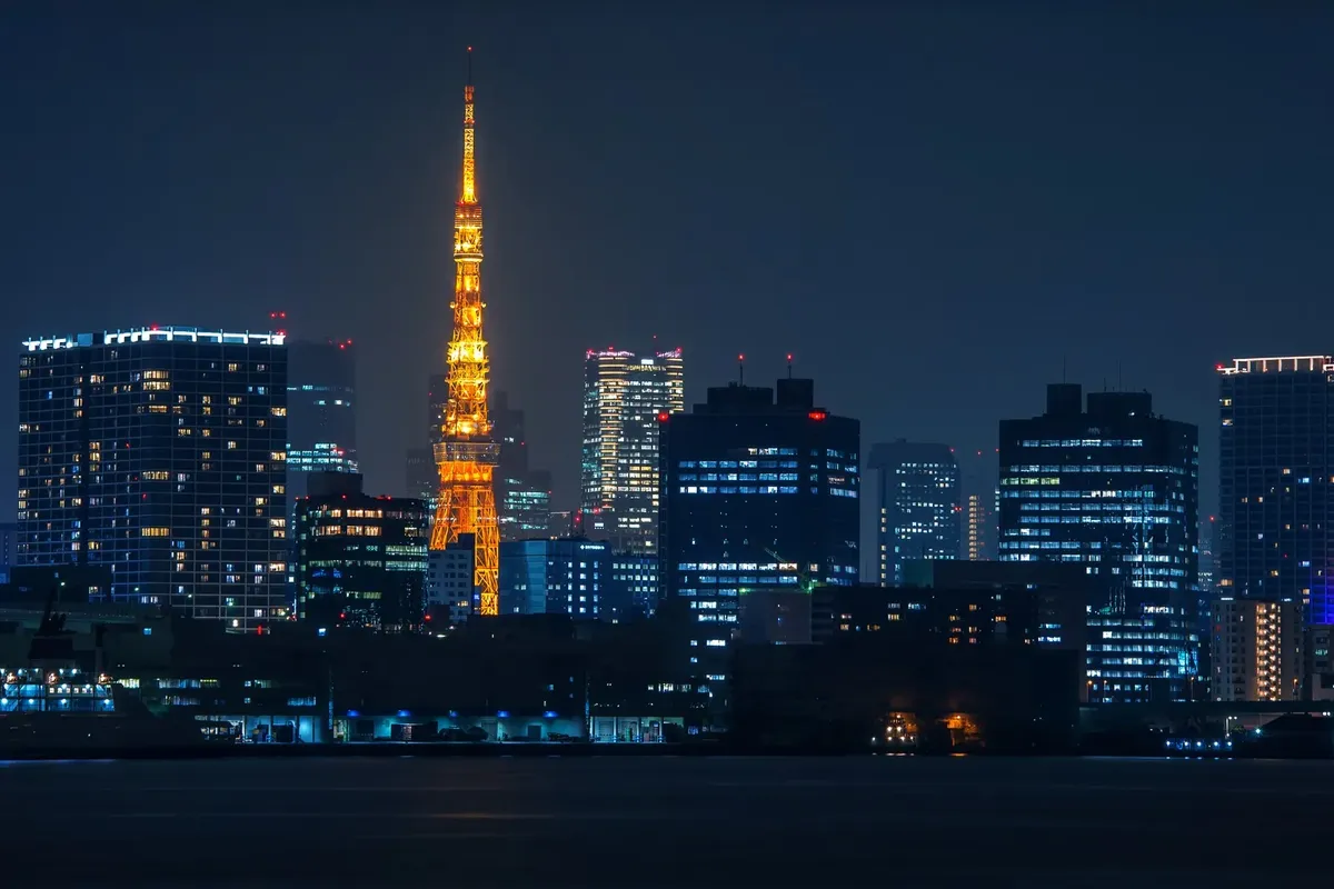 夜、水の向こうにライトアップされた東京タワーとオフィスビル。