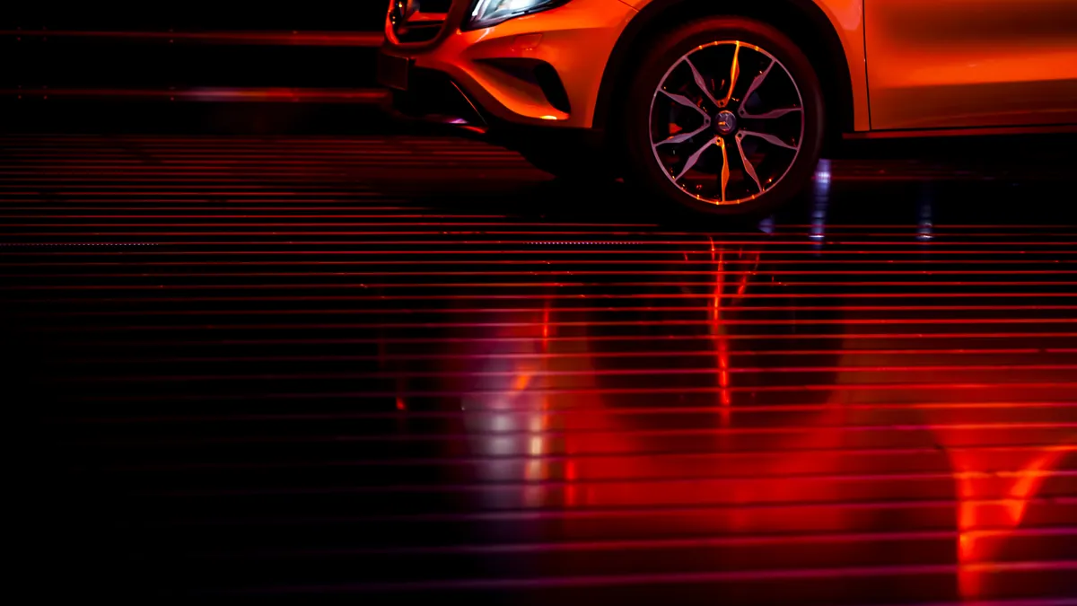 Um carro num stand de exposição sob luzes vermelhas num salão automóvel