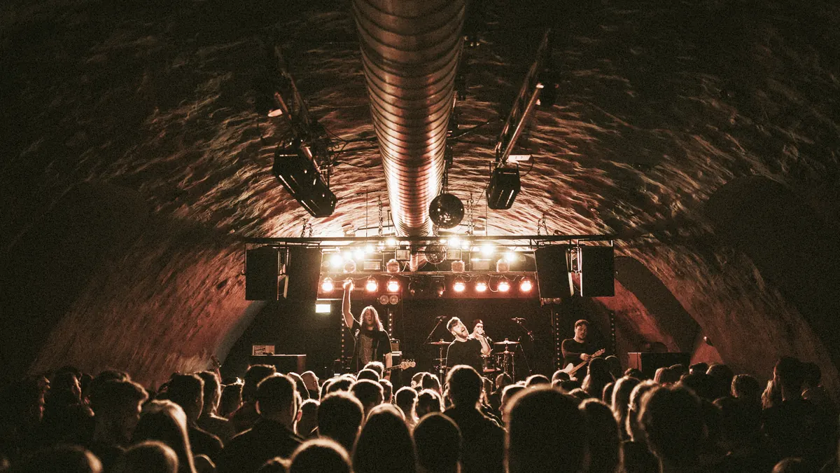 A band playing to a packed crowd in a dimly lit bar