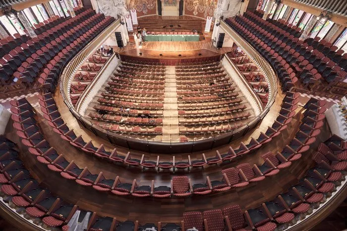Balconies and stalls of a horseshoe-shaped auditorium seen from the top tier.
