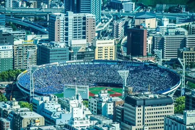 Um estádio de beisebol cheio em Yokohama visto de cima: um jogo da liga japonesa atrai um público numeroso e animado.
