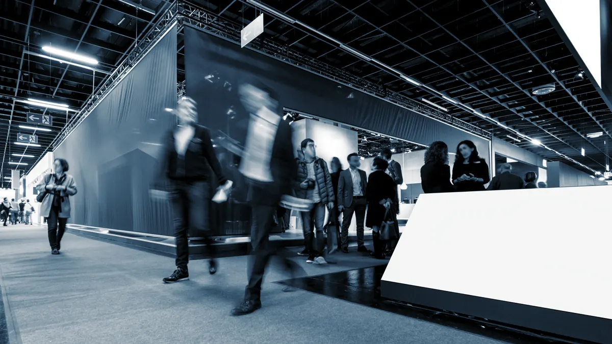 Visiteurs d'un salon professionnel circulant entre les stands