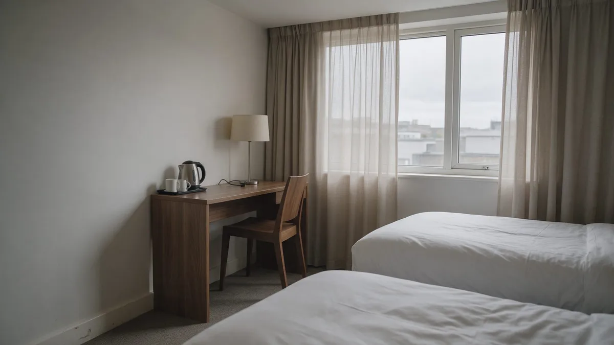 Une chambre d'hôtel à deux lits avec un bureau près de la fenêtre : une nuit sur la côte permet au groupe d'atteindre les vasières à marée basse.