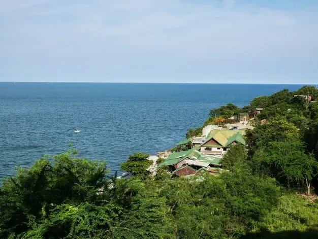 Un pequeño pueblo en una ladera verde sobre el mar.