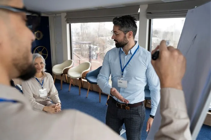 Ein Moderator mit Namensschild leitet eine Session am Flipchart.