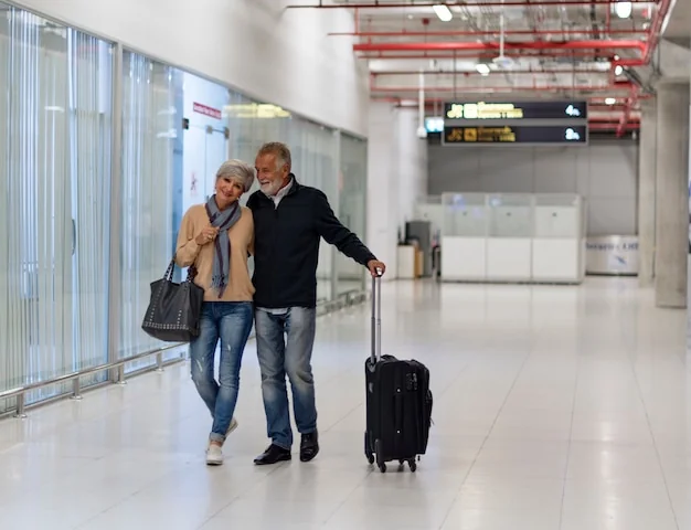 A couple walking through a terminal with a suitcase: clients flying on their own are where NDC shows up first.