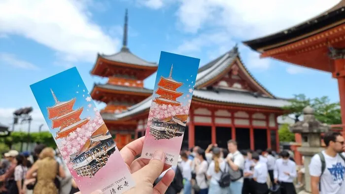 Bilhetes de entrada em papel erguidos num templo movimentado: numa visita de grupo fixa, uma entrada de grupo continua a ser a mais rápida.