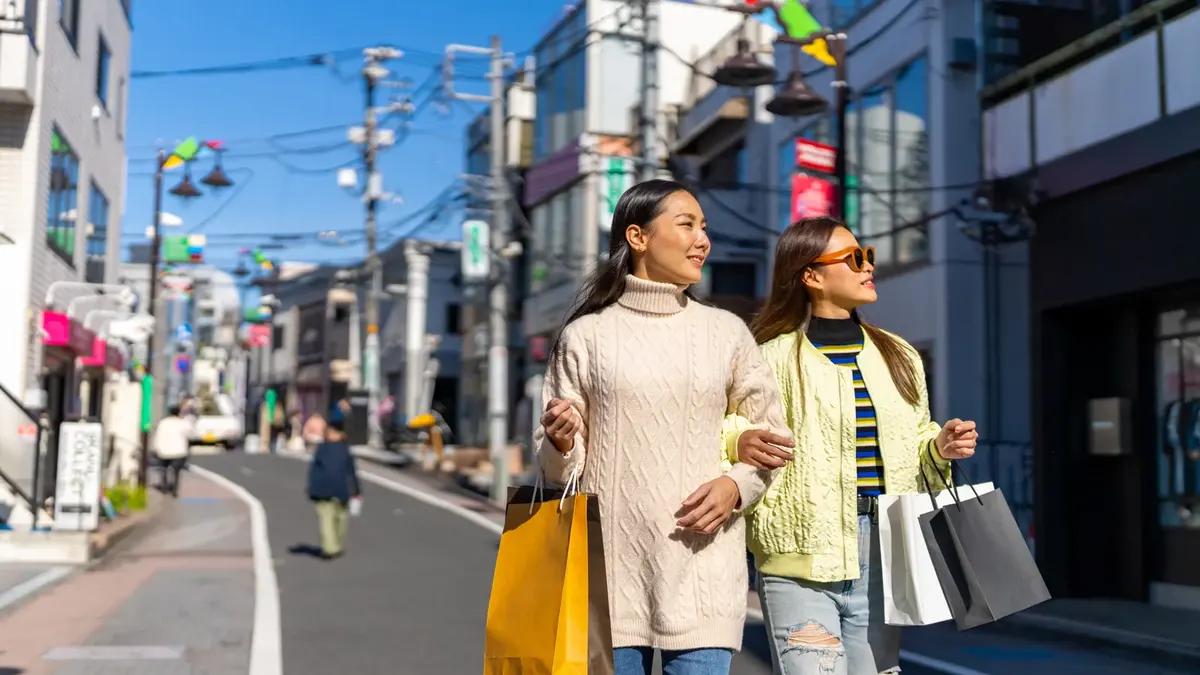 東京の通りで買い物袋を持つ友人たち。