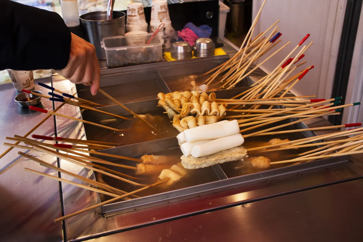 Fischkuchen und Reiskuchen köcheln an einem Straßenimbiss in Busan.
