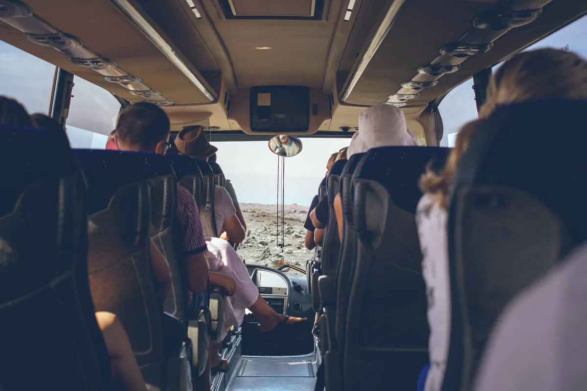 Eine Reisegruppe in einem Reisebus, vom hinteren Teil des Fahrzeugs aus gesehen.