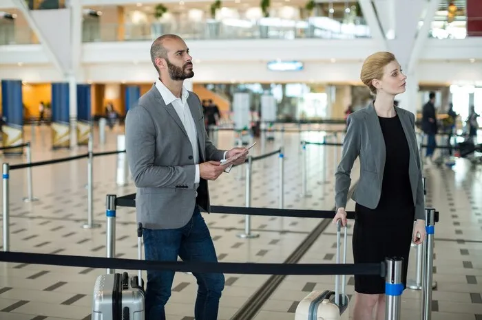 Des voyageurs avec leurs bagages font la queue à un comptoir d'enregistrement d'aéroport.