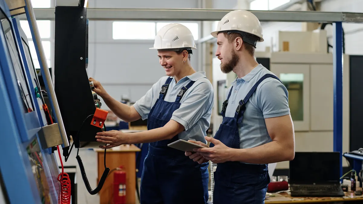 Deux techniciens contrôlent une machine CNC dans un atelier d'usine