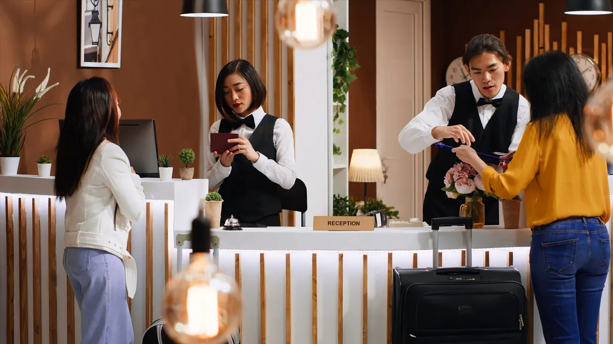 Hóspedes a fazer o check-in com a bagagem na receção de um hotel.