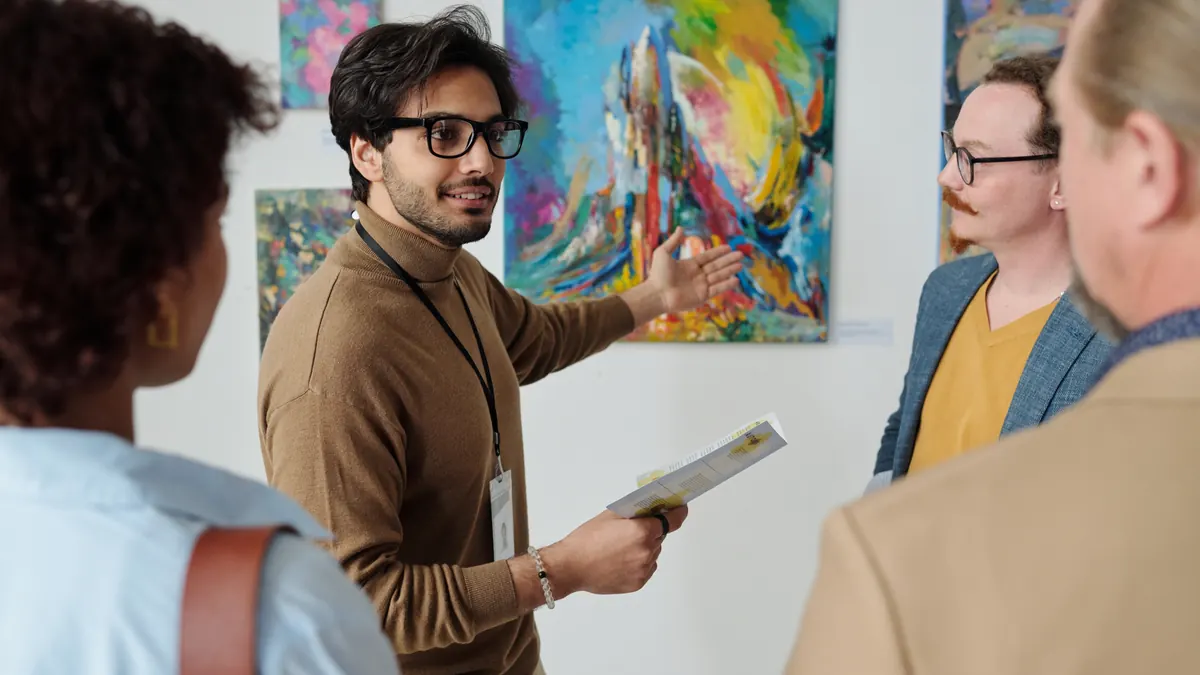 Un guide parle des œuvres aux visiteurs dans une galerie