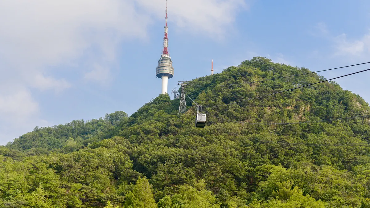 南山のNソウルタワーへ緑の斜面を上るケーブルカーのゴンドラ