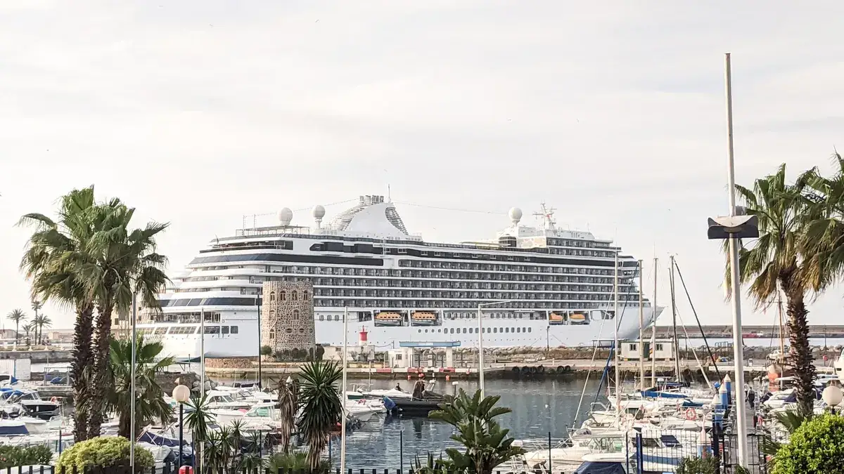 Un gran crucero al fondo de un puerto deportivo lleno de yates a motor