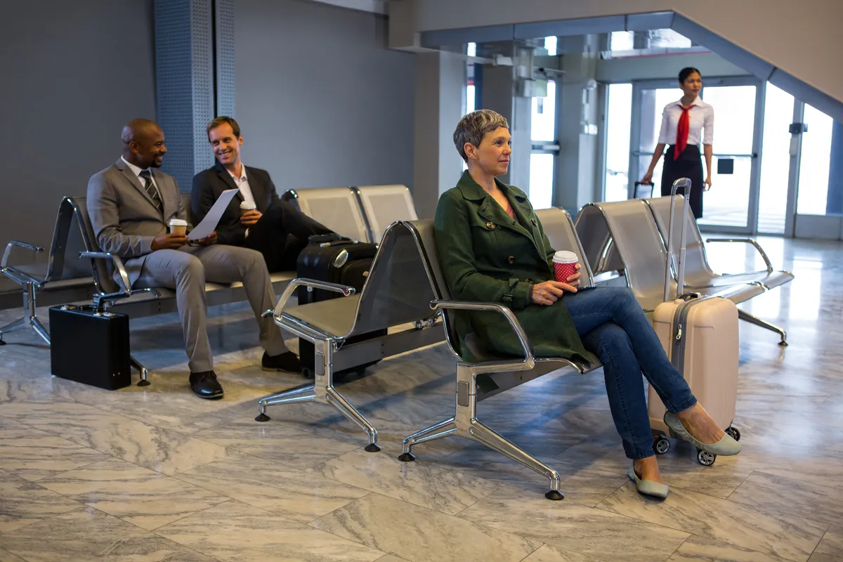 Viajantes com bagagem sentados numa sala de espera do aeroporto
