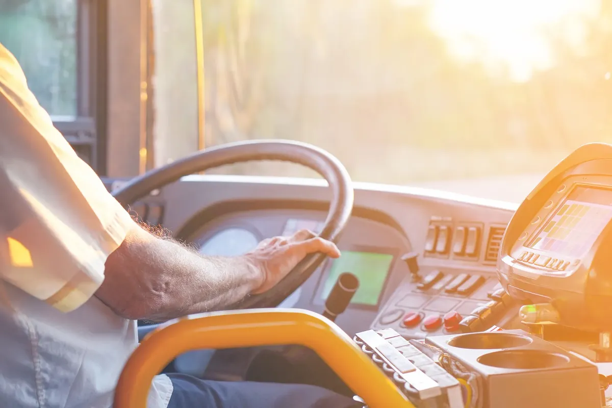 A mão de um motorista de autocarro no volante