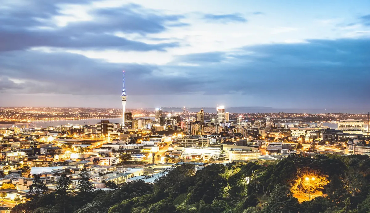 O horizonte de Auckland e a Sky Tower ao anoitecer, vistos do Mount Eden