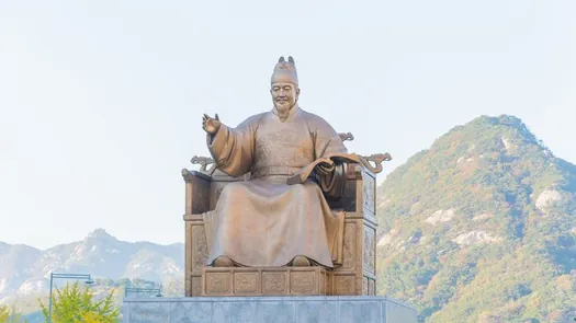 The King Sejong statue in central Seoul, with a mountain behind it.