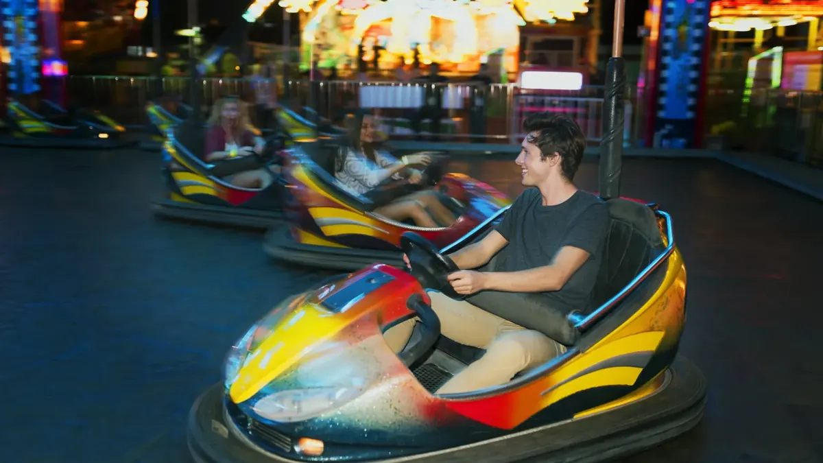 Amigos en los coches de choque de un parque de atracciones