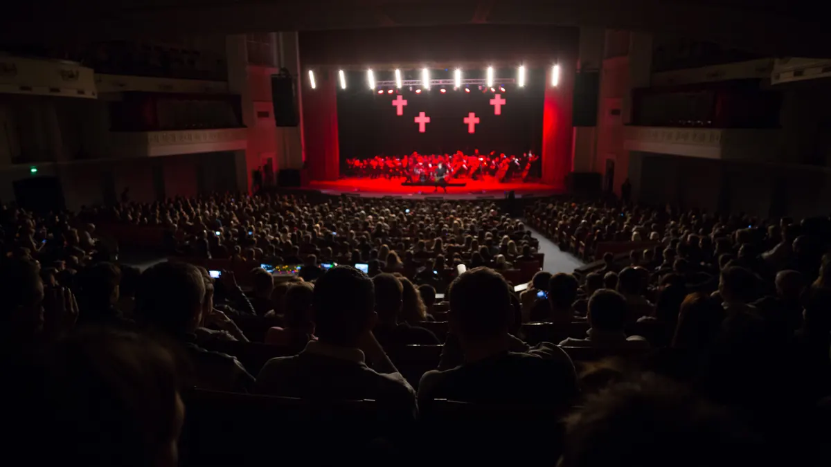 Une grande salle de concert remplie de spectateurs face à la scène