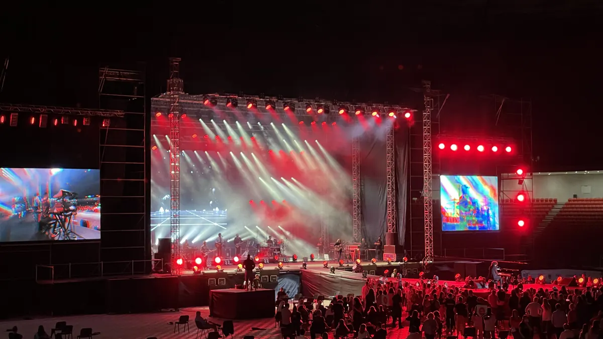 Un public regardant un spectacle sur une scène éclairée