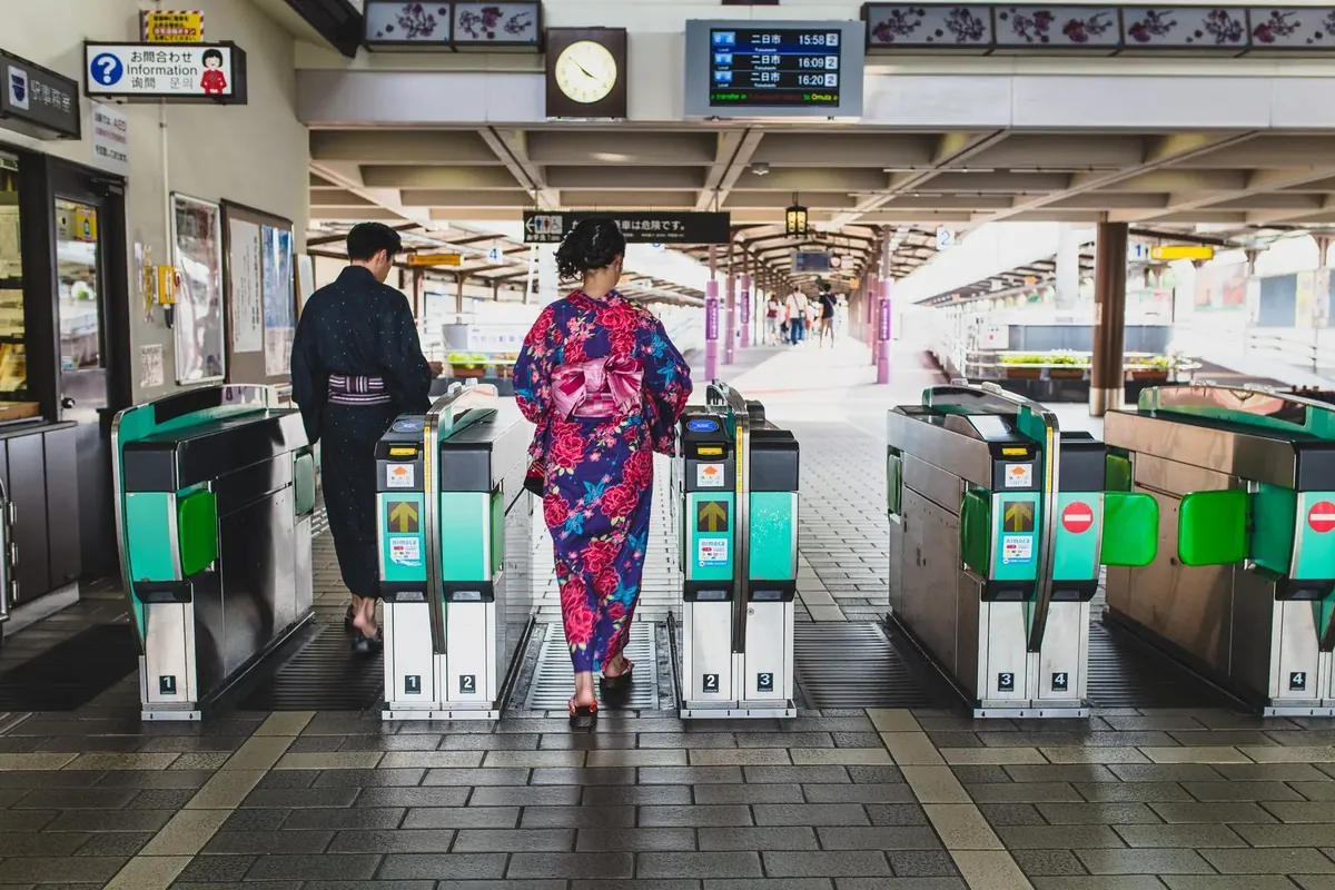 日本一座火车站的检票闸机,旅客正穿过闸机走向站台。