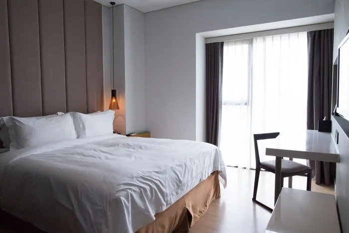 Una habitación de hotel con cama doble y escritorio, lista para recibir a un huésped.